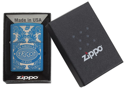 Blauwe Zippo-aansteker van voren gezien in een open zwarte geschenkdoos, omgeven door een met laser gegraveerd filigraanmotief met het Zippo-logo en "an american classic".